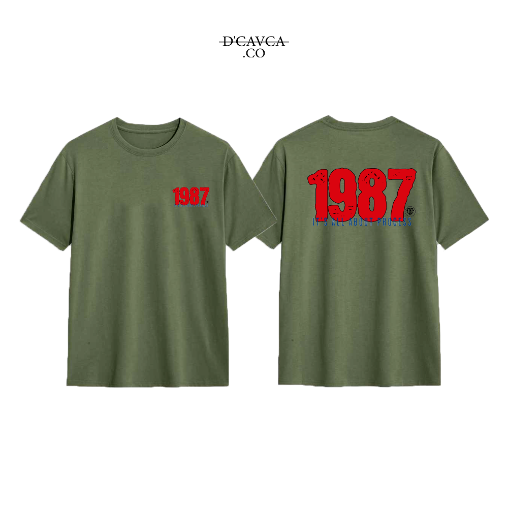 Green t-shirt with '1987' printed on the front and back, featuring the brand 'DCAVCA'.