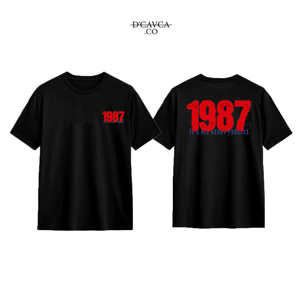 Black t-shirt with '1987' printed on the front and back, featuring the brand 'DCAVCA'.