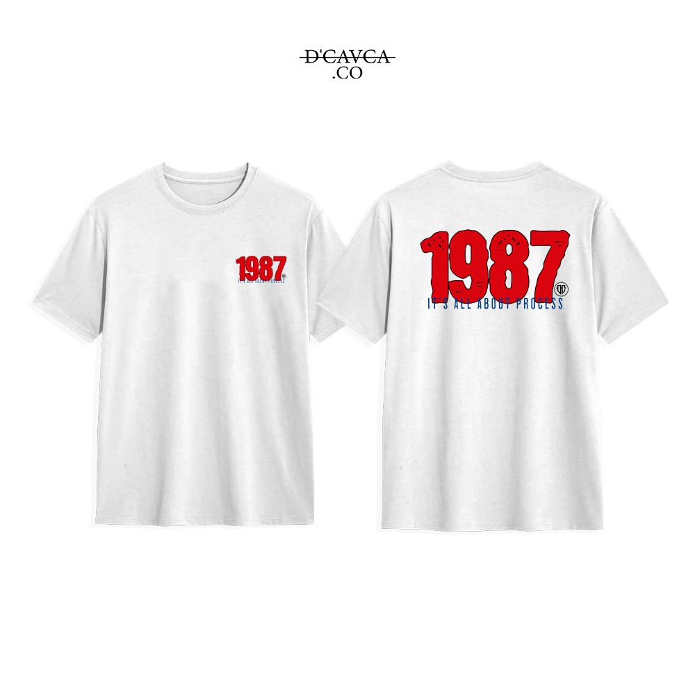 White t-shirt with '1987' printed on the front and back, featuring the brand 'DCAVCA'.